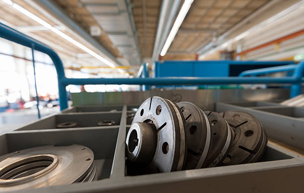 Automotive spare parts (disc brakes / wheel parts) in a storage rack at a large garage.